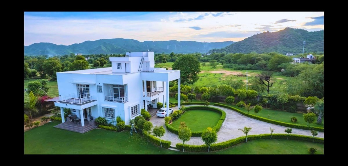 Drone shot of a white villa among green hills